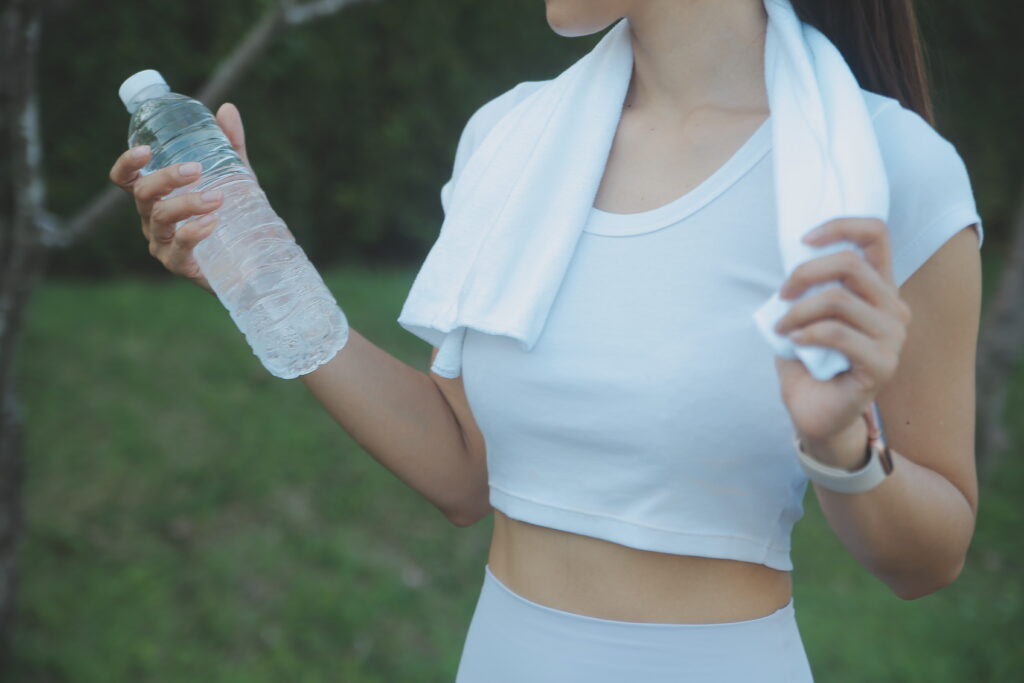 young woman drinking protein shake outdoors